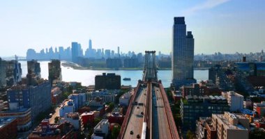 Doğu Nehri 'nin karşısındaki Williamsburg Köprüsü' nün girişine doğru uçuyor. Arka planda Manhattan 'ın sisli silueti. Hava görünümü.