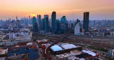 Tren Brooklyn 'i geçerken tren yaklaşıyor. Gün batımında Metropolis 'in yüksek gökdelenleri. New York, ABD.