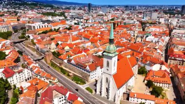 Slovakya 'nın Bratislava kentinden geçen çok sayıda araba var. İnsansız hava aracı turuncu çatılarla tarihi kısımda yükseliyor..