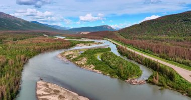 Alaska nehirleri boyunca görkemli manzaralar. Sarmal nehirler Alaska 'nın çarpıcı arazisinden akar, berrak bir gökyüzünün altındaki canlı yeşillikleri ve engebeli tepeleri ortaya çıkarır..