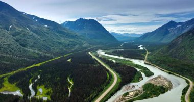 Alaska 'nın dolambaçlı nehirleri. Uçsuz bucaksız yeşil vadiler ve yüksek dağlar Alaska 'da nefes kesici bir manzara yaratır. Doğanın güzelliğini ve sükunetini gözler önüne serer..