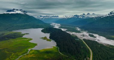Alaska uçsuz bucaksız, görkemli vahşi doğa. Alaska 'yı keşfedin. Dağları, nehirleri ve yeşillikleri bulutlu gökyüzünün altında..