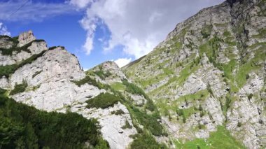 Dramatik dağ manzaralı mavi gökyüzü. Kayalık kayalıkları ve parlak mavi gökyüzü ile yemyeşil dağlar bu uzak bölgede çarpıcı bir doğal zemin oluşturur..