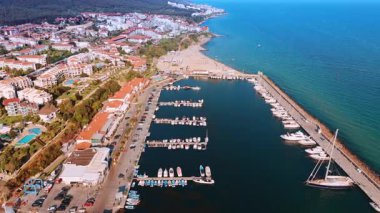 Rıhtımdaki demirli tekne ve yatların üzerinden uçmak. Bulgar tatil beldesi Sveti Vlas 'ın güneşli manzarası havadan görülüyor.