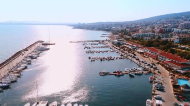 Barajın ve rıhtımların yanında çok sayıda tekne ve jet ski scooterları duruyor. Parlak güneş, Bulgaristan 'ın Sveti Vlas sahil beldesinin su manzarasını kamaştırıyor.