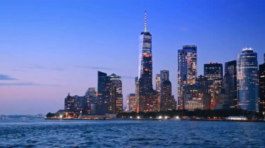 Manhattan, New York 'un göz kamaştırıcı silueti, alacakaranlıkta ABD. Şehir ışıkları açık güzel bir metropol. Tekneden bir görüntü..