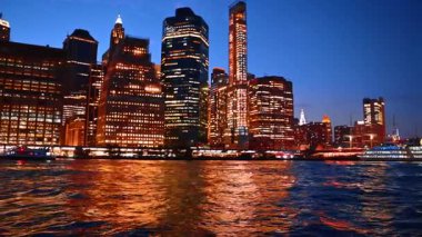 Modern New York 'un ışıltılı silueti Doğu Nehri' nin sularına yansıyor. 17. rıhtımın yanında çok katlı bir tekne durağı var..