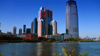 Jersey 'deki Hudson Nehri' nin kıyısından yürü. Nehrin karşısındaki Manhattan 'ın siluetini izliyorum. Bazı tekneler su yüzeyinde yüzüyor..