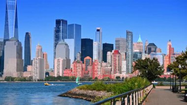 Jersey 'deki güzel rıhtımın yanından geç. Hudson Nehri 'nin mavi sularından gemiler geçiyor. Arkaplanda Manhattan silueti.