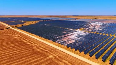 Güneş panelleriyle kaplı alan boyunca çıplak alanın üzerinden uçmak. Yeşil enerji üretimi.