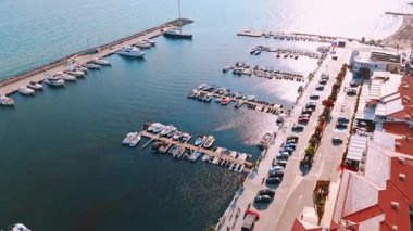 Güneşli bir günde huzurlu marina manzarası. Açık mavi gökyüzünün altında, güneşli bir günün dinginliğini yansıtan, teknelerle dolu canlı bir marina..