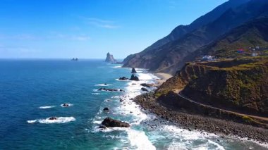 Atlantik Okyanusu 'nun köpüklü beyaz dalgaları kıyıdaki kayalara çarptı. İHA görüntüleri Tenerife 'nin güneşli sahillerinde, Kanarya Adaları, İspanya.