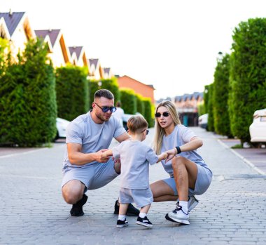 Aile güneşli banliyö gününün tadını çıkarıyor. Bir aile güneşli bir günde banliyölerinde birlikte oynar, neşeli anlar yaratır ve bağ kurar..