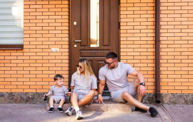 Aile merdivenlerde birlikte eğleniyor. Bir aile, evlerinin merdivenlerinde oturup kahkahalarını ve neşeli anlarını paylaşır ve birlikte vakit geçirirler..