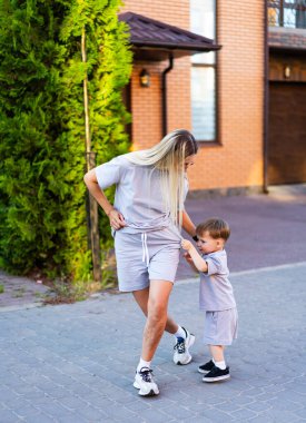 Anne ve oğlu dışarıda oynuyor. Güneşli bir günde, sıcak bir mahallede, bir kadın ve oğlu birlikte eğleniyorlar. Kefaletlerini gösteriyorlar..