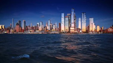 New York 'un çarpıcı ufuk çizgisi gökyüzü maviliği ve nehir manzarası arasında. Günbatımında Doğu Nehri 'nde tekne yolculuğu..