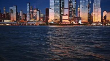 İnanılmaz New York silueti batan güneşle aydınlanıyor. Nehir manzaralı Manhattan binalarına bak.