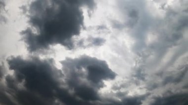 Gökyüzü tamamen gri bulutlarla kaplı. Atmosferde oluşan dramatik bulutların düşük açılı görüntüsü. Zaman Uygulaması.