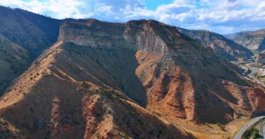 Bitki örtüsü olmayan ulaşılamaz kayalar. Pofuduk beyaz bulutlu mavi gökyüzü. Price Canyon, Utah, ABD.