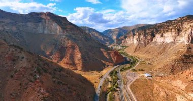 Taşıma araçları, çarpan kayalar boyunca otobanlardan geçiyor. İnsansız hava aracı görüntüleri, ABD 'nin Utah eyaletindeki Price Canyon Dinlenme Alanı' ndan geçiyor..