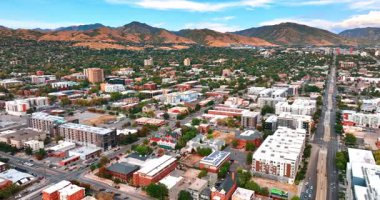 Bir sürü yeşillikle şehir manzarası görüntüsü. Arkaplanda çıplak dağlar. Salt Lake City, Utah, ABD.