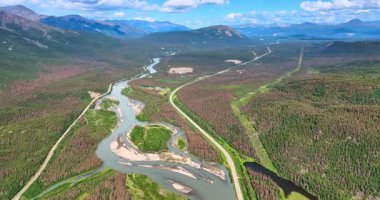 Dallanan nehir boyunca iki otoyol inşa edildi. Muhteşem dağlardaki vadide insansız hava aracı görüntüleri. Alaska vahşi doğası.