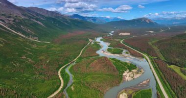 İki otoyol arasında akan nehrin sığ dallanan deltasının üzerindeki görüntüler. Alaska, ABD 'nin muhteşem kayalık manzarasına hava perspektifi.
