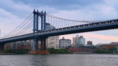 Tren Manhattan Köprüsü 'nden geçiyor. Doğu Nehri 'ndeki su manzarasının alçak açılı görüntüsü..