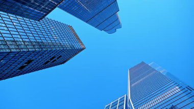 Görkemli gökdelenler açık mavi gökyüzünü yansıtıyor. New York, ABD 'nin yüksek binalarının alçak açılı manzarası..