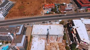 Sahilde inşaat halindeki yüksek binalar. Deniz kıyısında vinçleri ve iskelesi olan yüksek bir yapı inşa ediliyor..