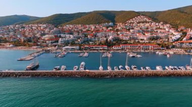Deniz kenarındaki tepelerde tekneleri ve şehirleri olan bir liman. Tekneli bir limanın havadan görünüşü ve deniz kıyısında tepelere inşa edilmiş bir şehir..