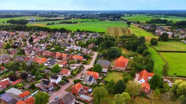Hollanda kırsalının kırmızı çatıları ve açık yeşil arazileri olan insansız hava aracı fotoğrafı. Konut evleri, kırmızı çatıları ve geniş yeşil arazileri olan Hollanda kırsalları.