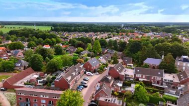 Hollandalı evlerin ve yeşil ağaçların hava aracı görüntüleri. Evleri, kırmızı çatıları ve yazın bir sürü yeşil ağacı olan Hollandalı bir mahallenin insansız hava aracı görüntüleri..