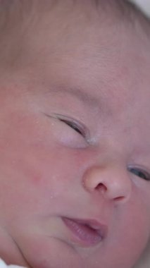 Arkada yatan tatlı, küçük bir çocuk. Beyaz kumaş içinde küçük bir bebeğin portresi. Dikey video