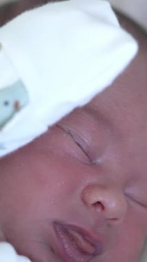 Beyaz kumaş içinde küçük bir bebeğin portresi. Arkada yatan tatlı, küçük bir çocuk. Dikey video