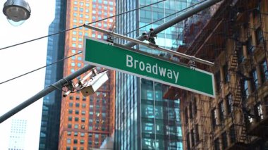 New York 'ta Broadway tabelası ve gökdelenler. Arkasında gökdelenler olan yeşil bir Broadway sokak tabelası..