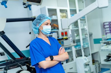 Ekipmanların yanındaki ameliyathanede sağlık görevlisi. Gelişmiş tıbbi ekipmanların yanında duran bir sağlık görevlisinin yan profili..