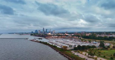 Flying closer to the big yacht club with numerous boats. Scenery of green beautiful Cleveland, Ohio, USA from drone on a dull day.