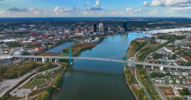 Flying over the Maumee River in Toledo, Ohio, USA at sundown. Approaching the Anthony Wayne Bridge with cars riding by.