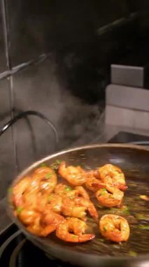 Biberiyeli ızgara biftek ve duman. Biberiye dallı iki ızgara biftek dumanlı bir barbeküde pişiyor..