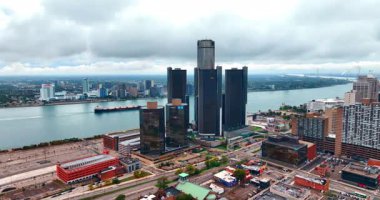 Approaching group of dark high-rise buildings of the Renaissance Center in Detroit, Michigan, USA. Waterscape of the Detroit River at backdrop.