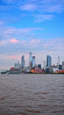 Boat travel by the ragged waterscape of the East River. View on the skyline of New York, USA from the riverscape. Vertical video.