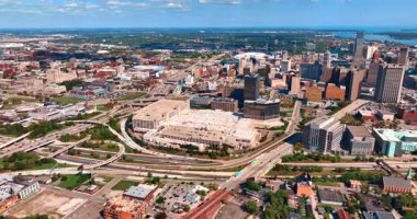 Numerous cars ride by the branched roads around the city downtown. Drone footage approaching the midtown of Detroit, Michigan, USA.