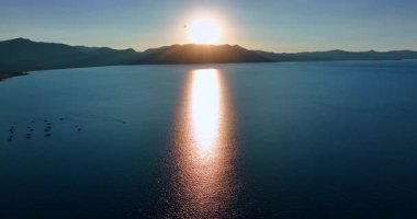 Soft light of setting sun on the waterscape of Lake Tahoe, California, USA. Many boats stand on the lake at sunset. Aerial view.