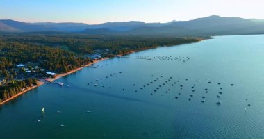 Approaching the numerous boats on the waterscape of Lake Tahoe, California, USA. Sunset time footage from drone.
