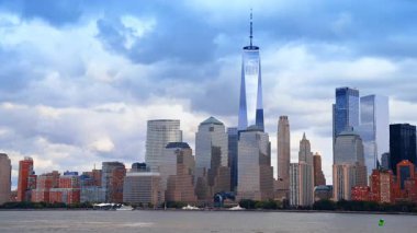 Top of the One World Trade Center at the backdrop of dark overcast sky. Low angle view on Manhattan skyline from the riverscape.