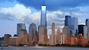 One World Trade Center in the skyline of Manhattan, New York, USA. Low angle view from the riverscape. Birds fly near camera.