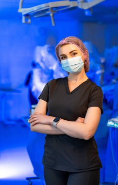 Siyah üniformalı bir hemşire. Ameliyat odasında duran siyah önlüklü hemşire..