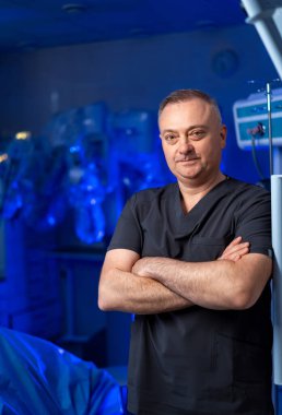 Cerrah robot sistemi operasyona hazırlıyor. Tıbbi uzman modern hastane ameliyathanesindeki robot cerrahi makinesini ayarlıyor..