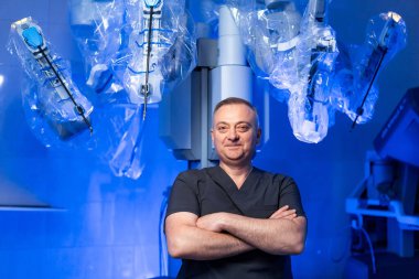 Cerrah ve robot cerrahi teknolojisi. Hastanedeki doktor gelişmiş robotik cerrahi sisteminin yanında çalışıyor..